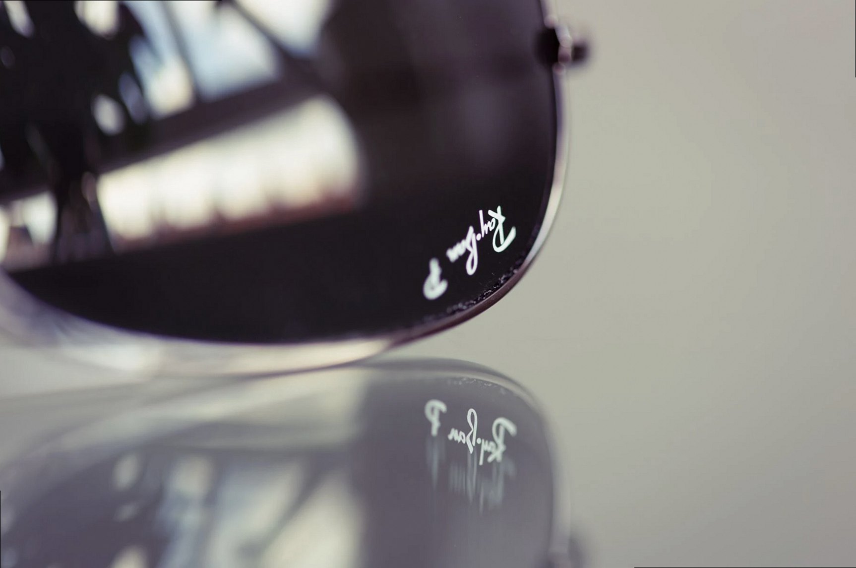 Imagen detallada de unas gafas de sol de aviador con el reflejo de la marca.